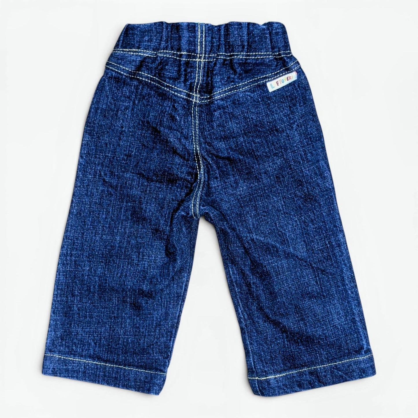 A pair of Leftovers Club Sammy Sailor indigo denim jeans for kids, featuring an elastic waistband, front pockets, and contras