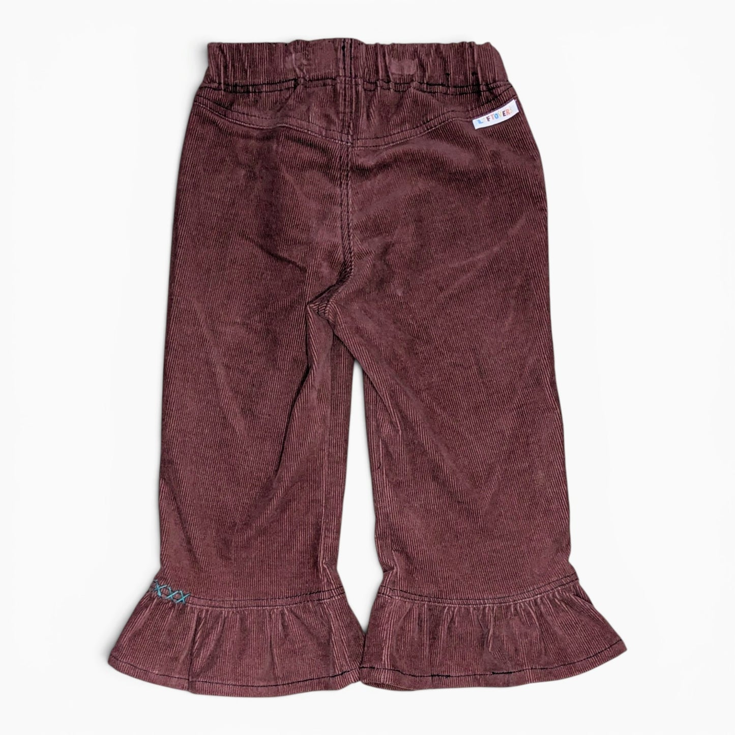 A pair of toddler's wide-leg corduroy pants in a dusty plum-brown color, featuring an elastic waistband and ruffled hems, laid flat against a white background.