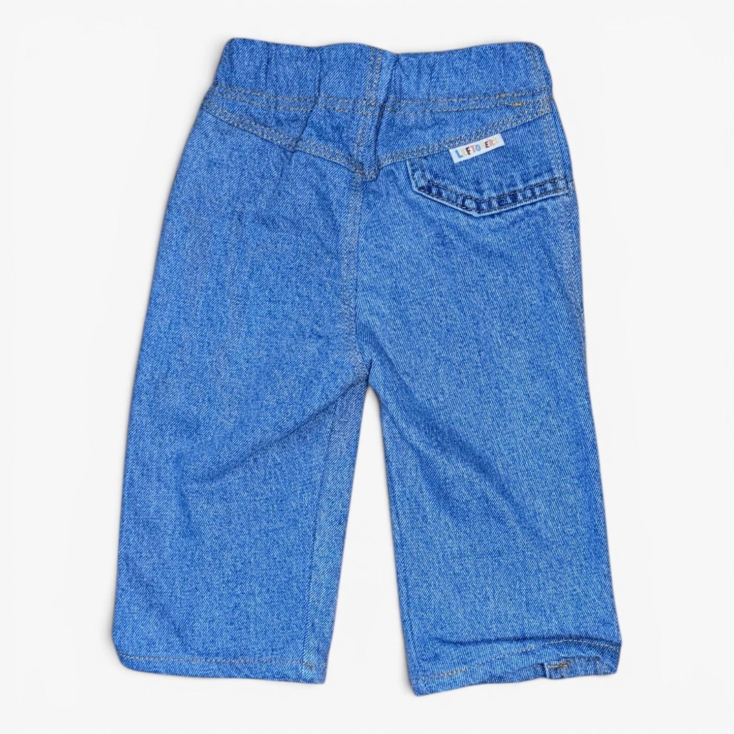 A pair of Leftovers Club Stevie Straight blue denim jeans for kids, featuring an elastic waistband, front pockets, and contra