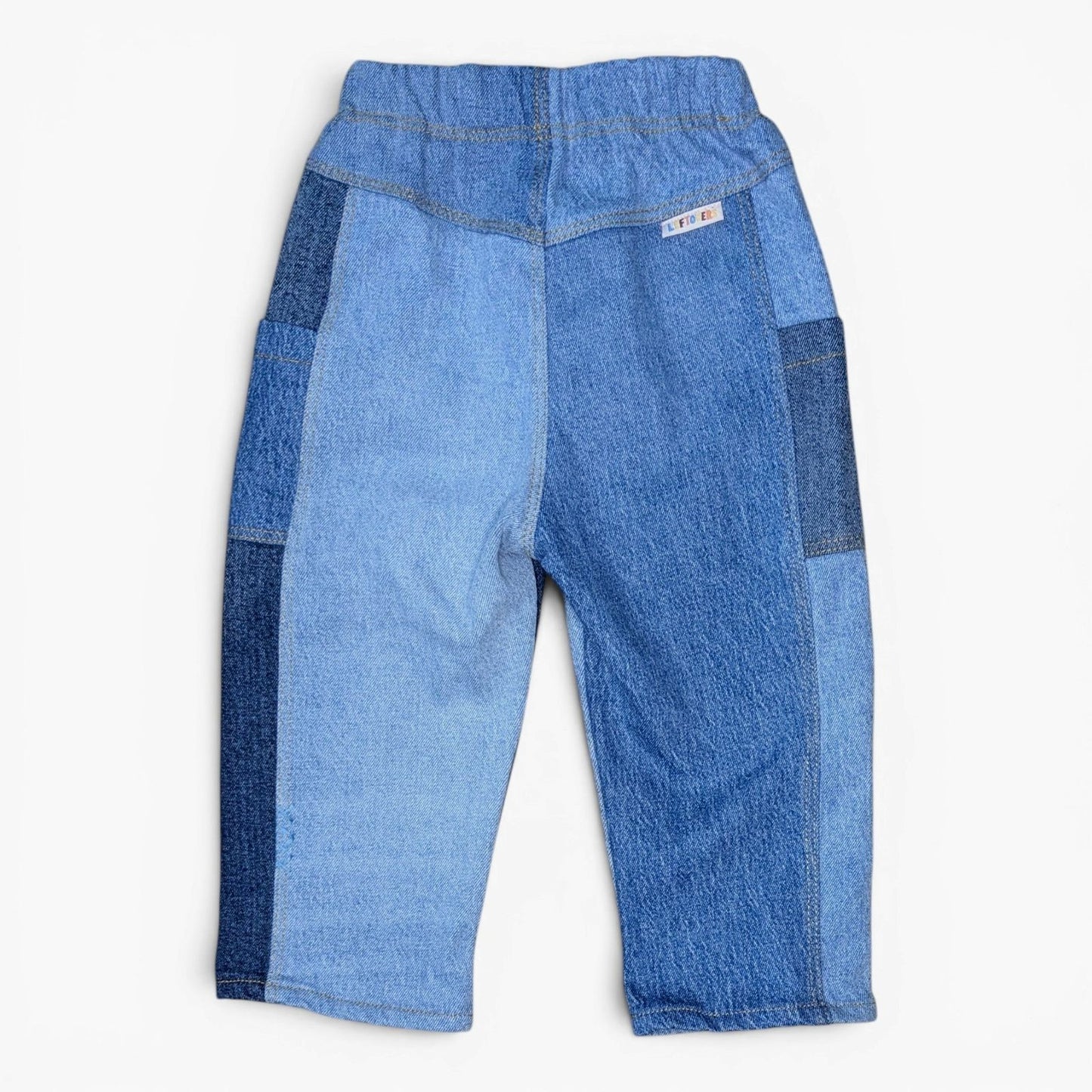 A pair of Leftovers Club Cameron Cargo blue denim cargo pants with a split-colour design, featuring light blue denim on the l