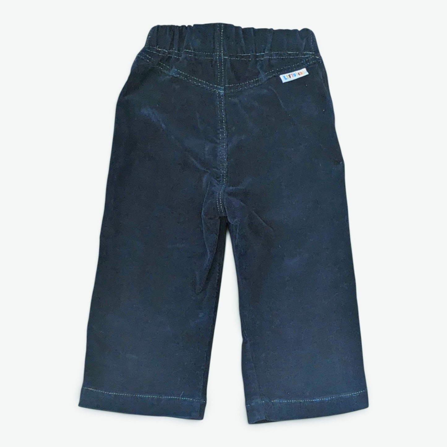 Leftovers club dark blue cord jeans for toddlers. Stevie straight style featuring an elastic waistband. Back view on white ba