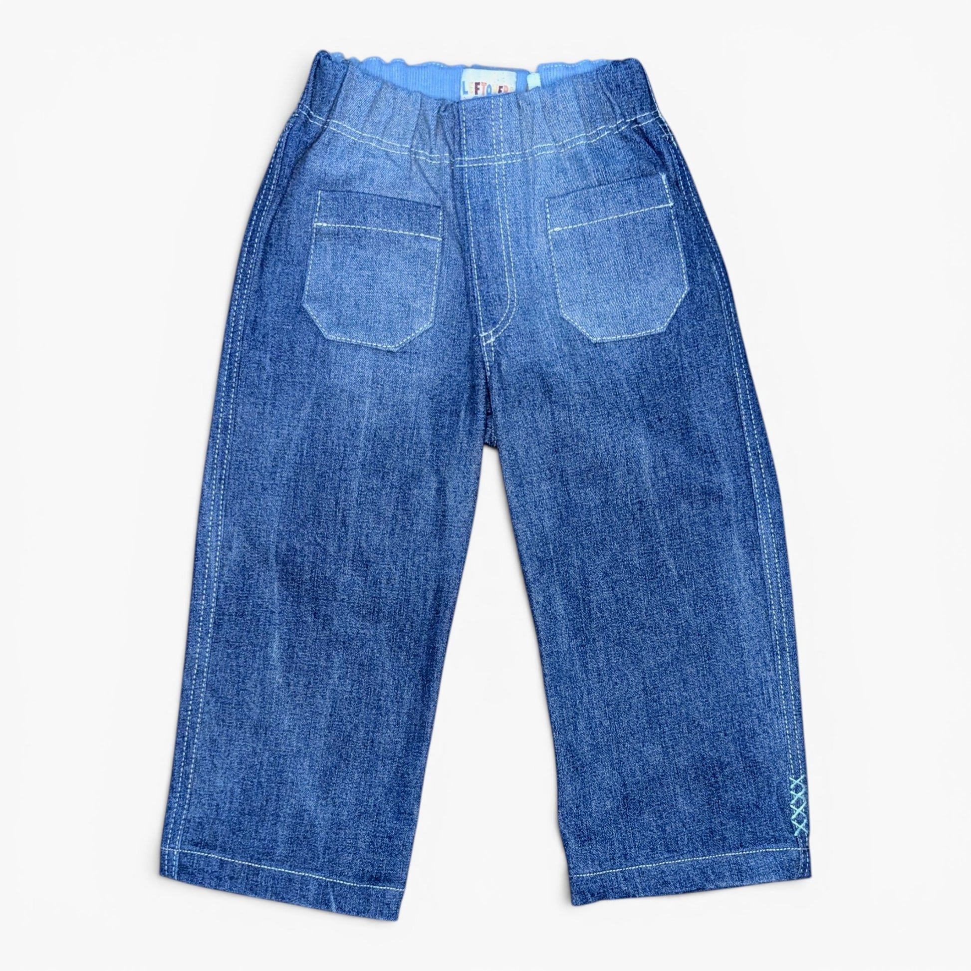 A pair of blue denim pants with a wide elastic waistband, two large patch pockets on the back, and rolled cuffs, shown flat on a light background.