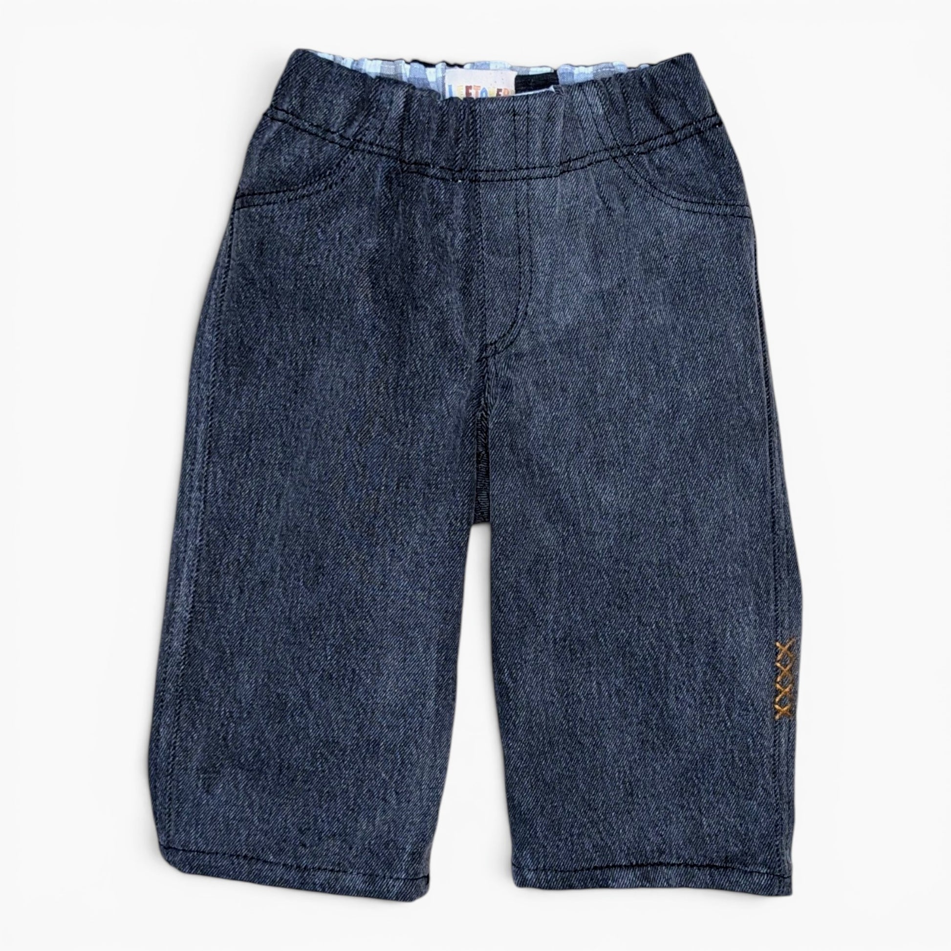 A pair of washed black denim pants for toddlers with an elastic waistband and decorative gold embroidered details on the side, shown flat on a white background.