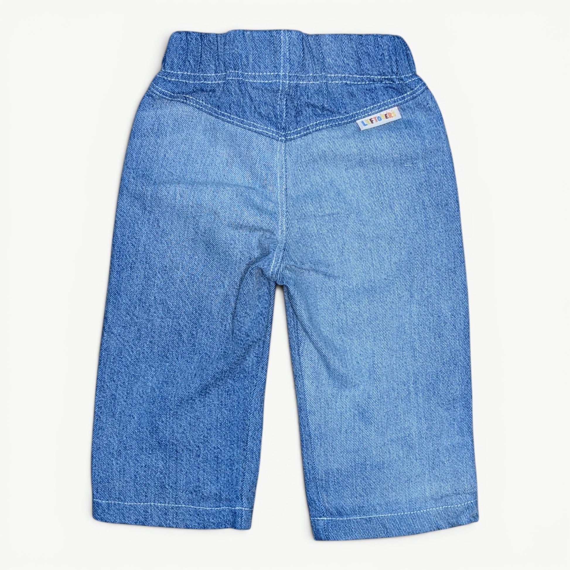 A pair of blue denim shorts with an elastic waistband, shown from the back on a light off-white background.
