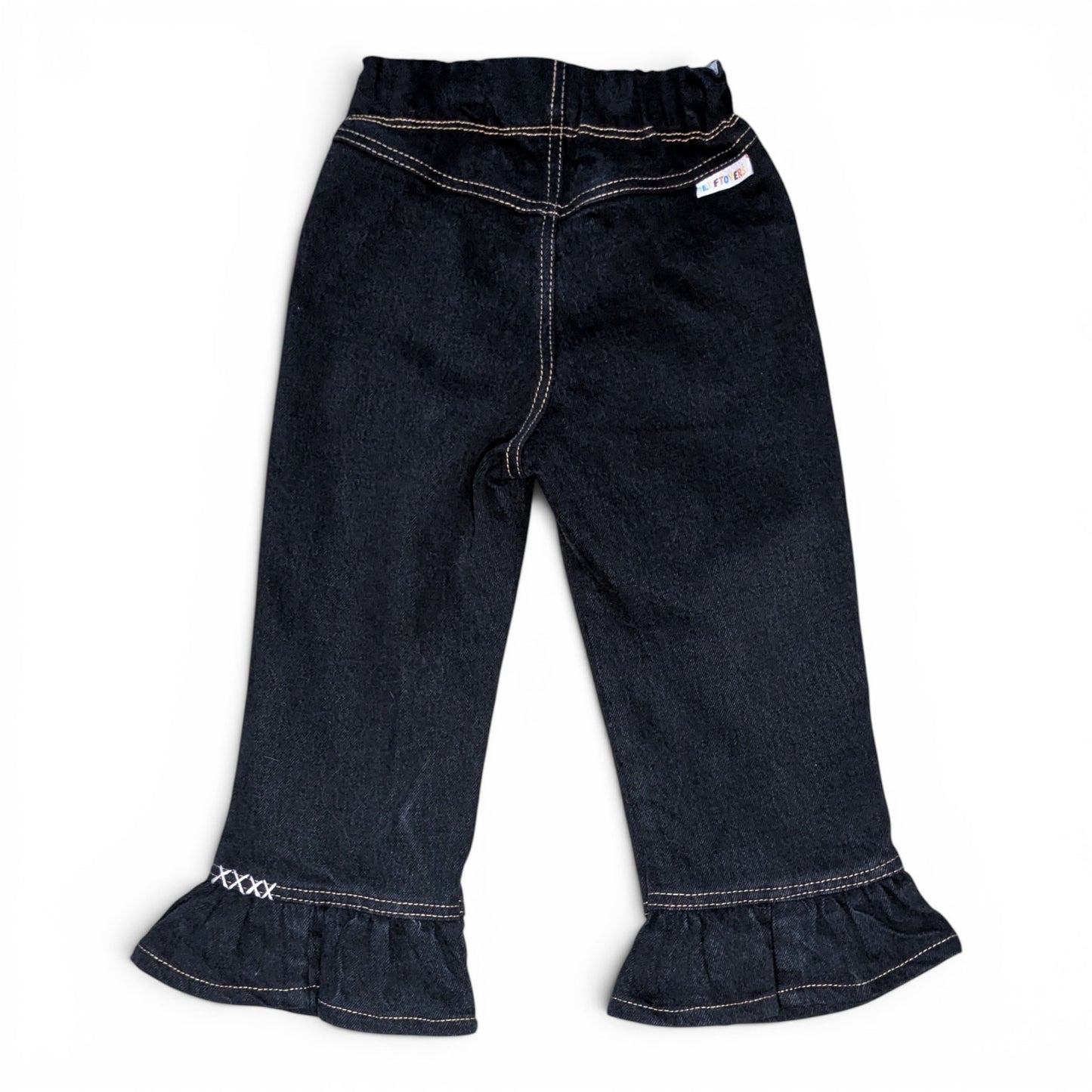 Dark wash denim cropped pants with a ruffled hem and white contrast stitching, shown flat on a white background.