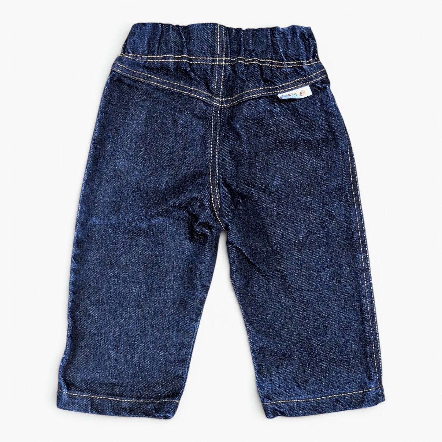 A pair of dark blue denim baby pants with an elastic waistband and white contrast stitching, shown flat on a white background.