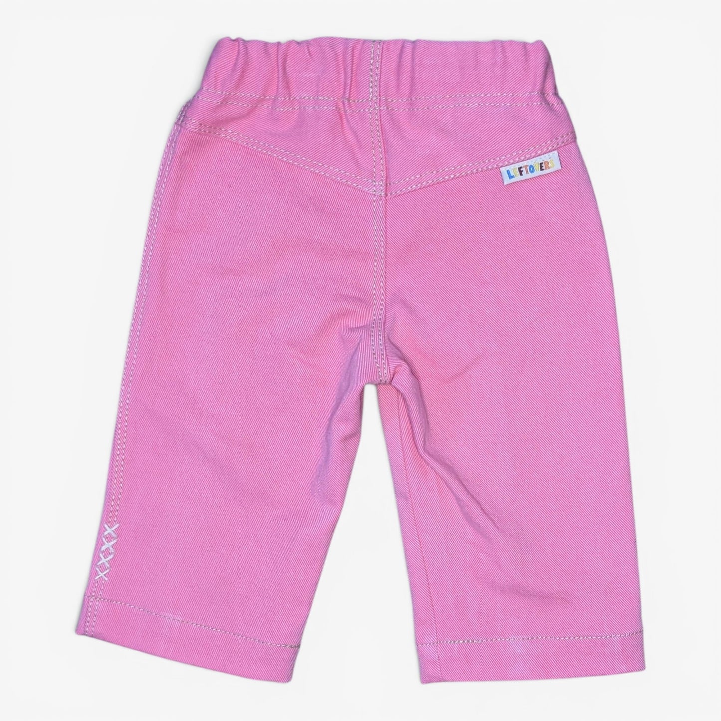 Pink toddler pants with contrast stitching, elastic waistband, and a small white brand label on the back right pocket, shown against a plain white background.