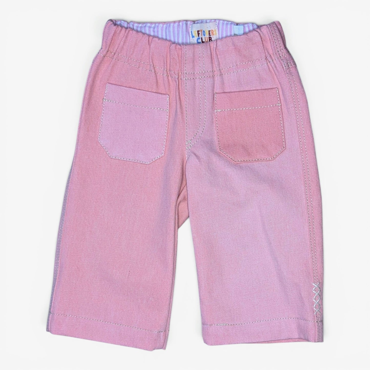 Pink denim jeans for kids with an elastic waistband, two front patch pockets, and contrast stitching, shown flat on a white background.