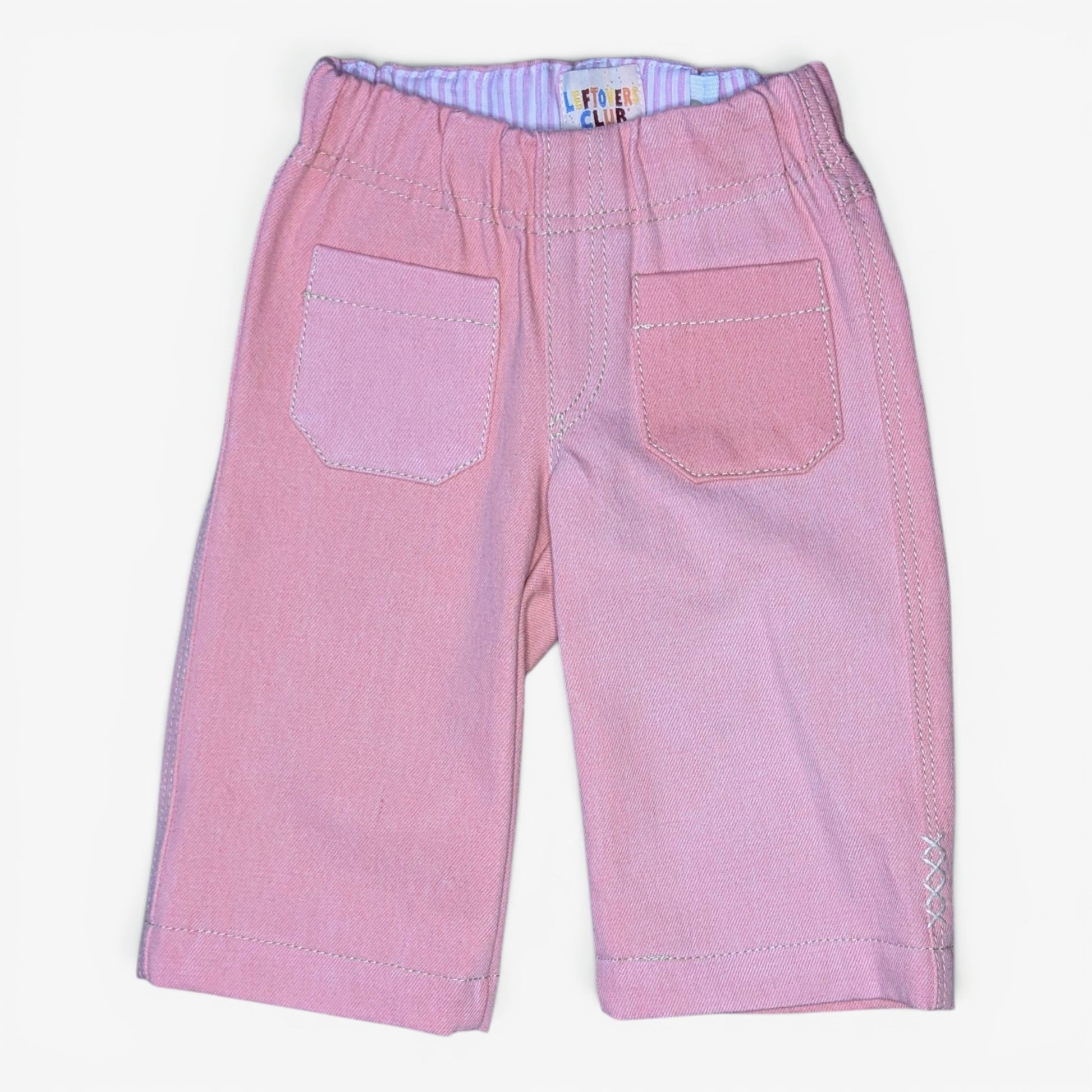 Pink denim jeans for kids with an elastic waistband, two front patch pockets, and contrast stitching, shown flat on a white background.