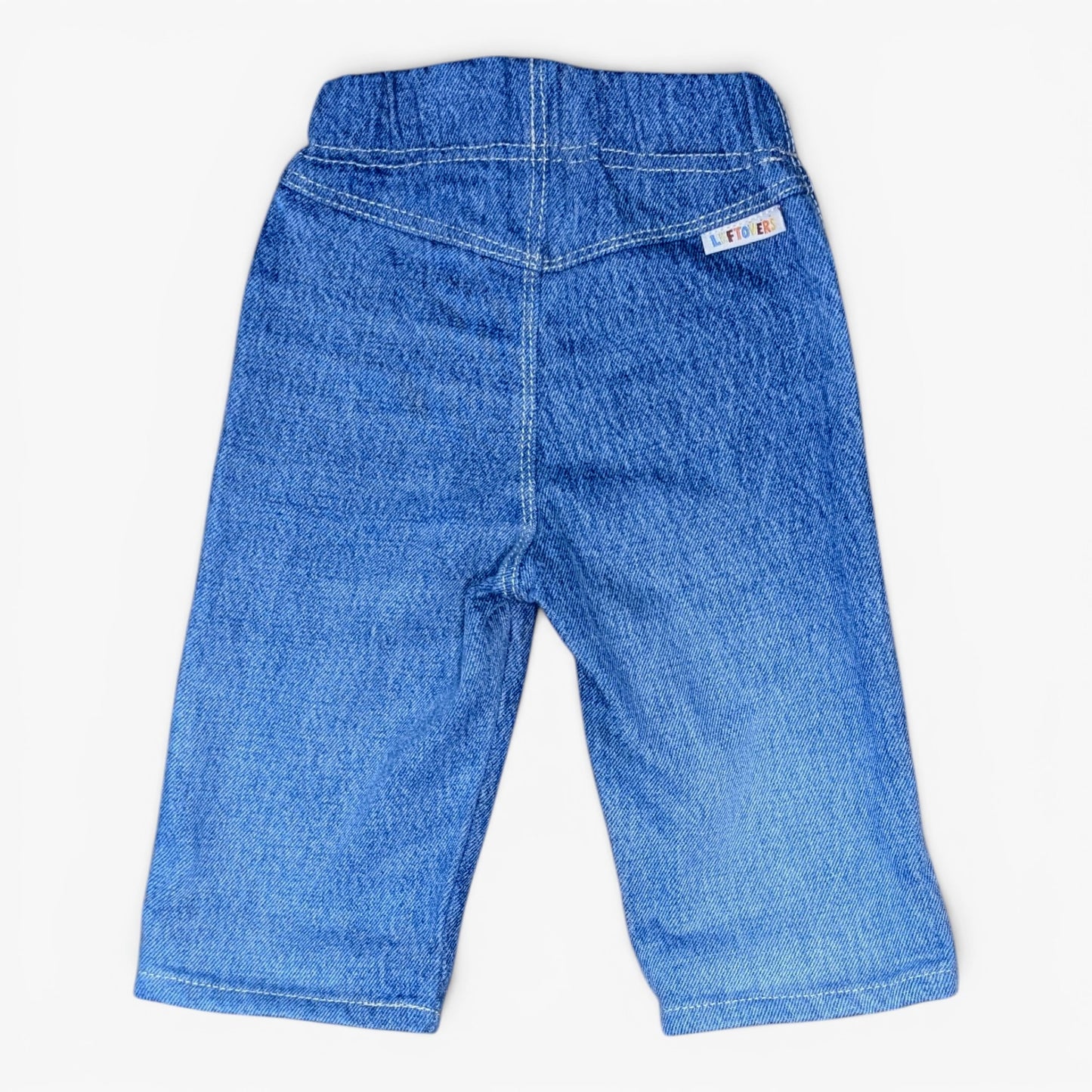 Blue denim pants shown from the back, featuring an elastic waistband and a small white brand tag on the upper right side, photographed against a plain white background.