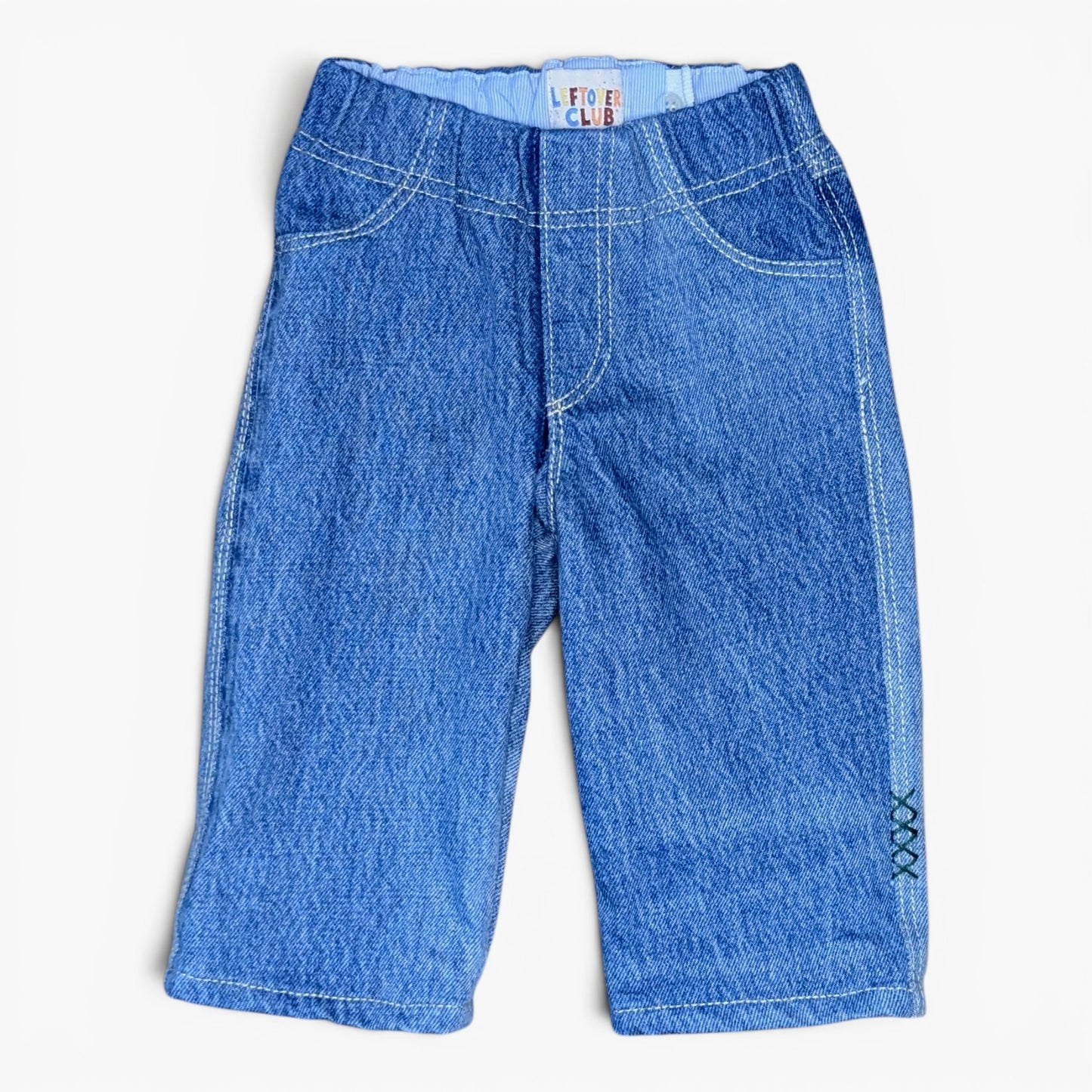 A pair of blue denim jeans for toddlers, featuring a wide elastic waistband, classic five-pocket design, and decorative contrast stitching, shown flat on a white background.