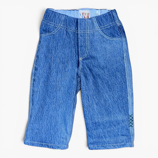 A pair of blue denim jeans for toddlers, featuring a wide elastic waistband, classic five-pocket design, and decorative contrast stitching, shown flat on a white background.