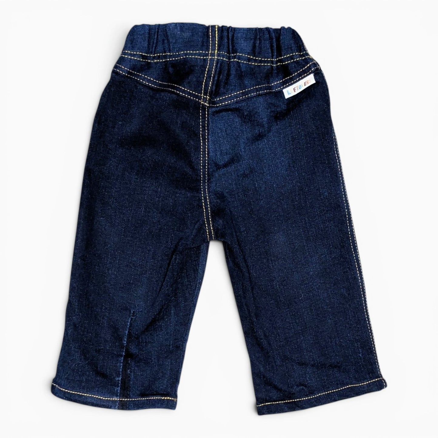 A pair of dark blue denim toddler pants with contrast light-colored stitching and an elastic waistband, shown flat on a white background.