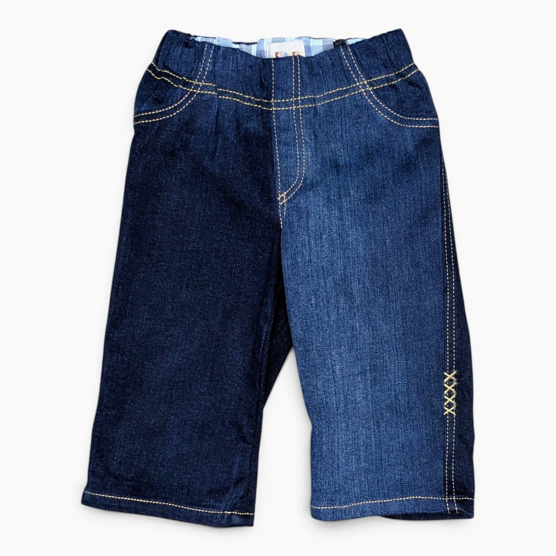 A pair of dark blue denim pantswith contrasting light beige stitching, displayed flat against a plain white background.