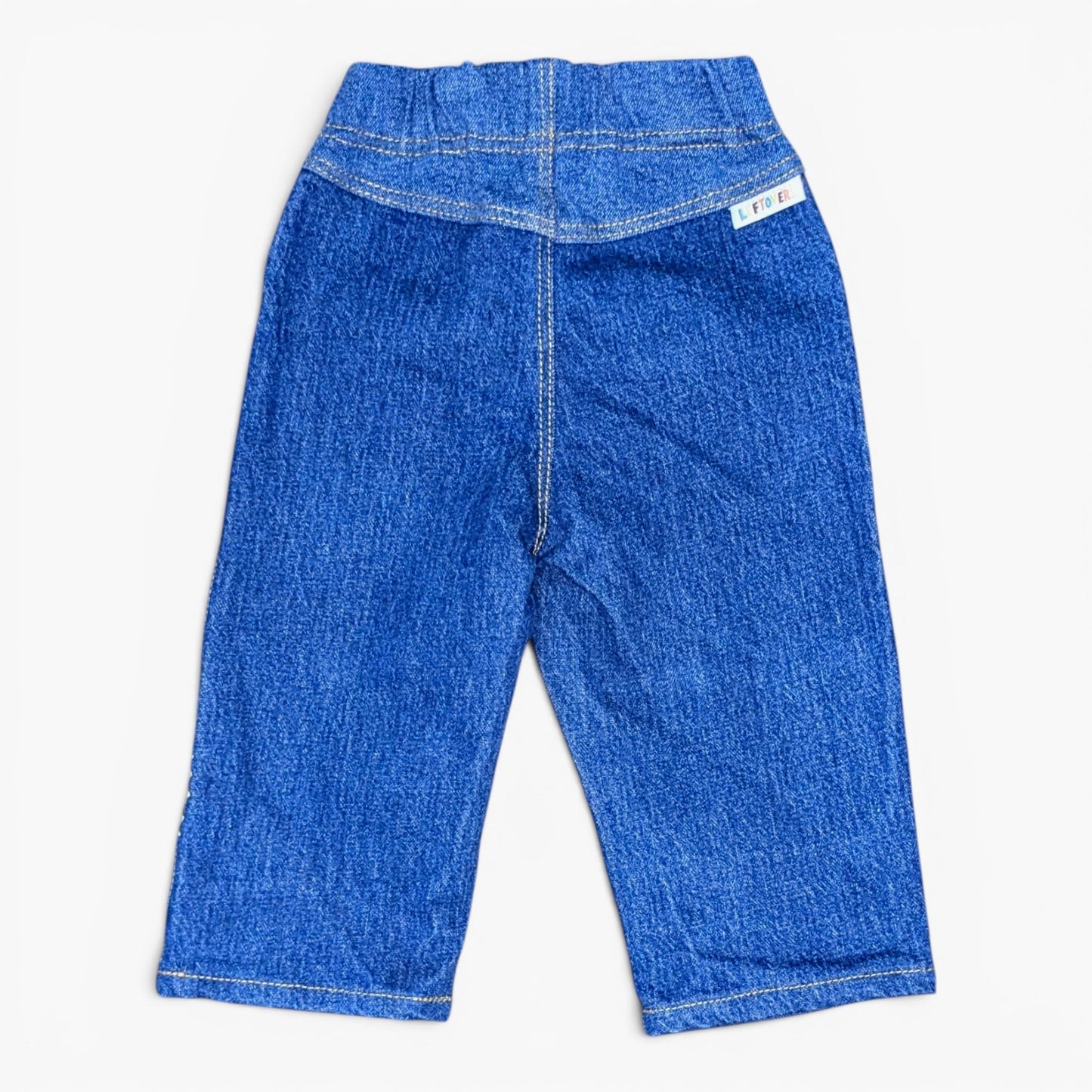 Blue denim pants shown from the back, featuring a wide elastic waistband, a central seam, and a small white brand tag on the upper right side, laid flat against a light background.