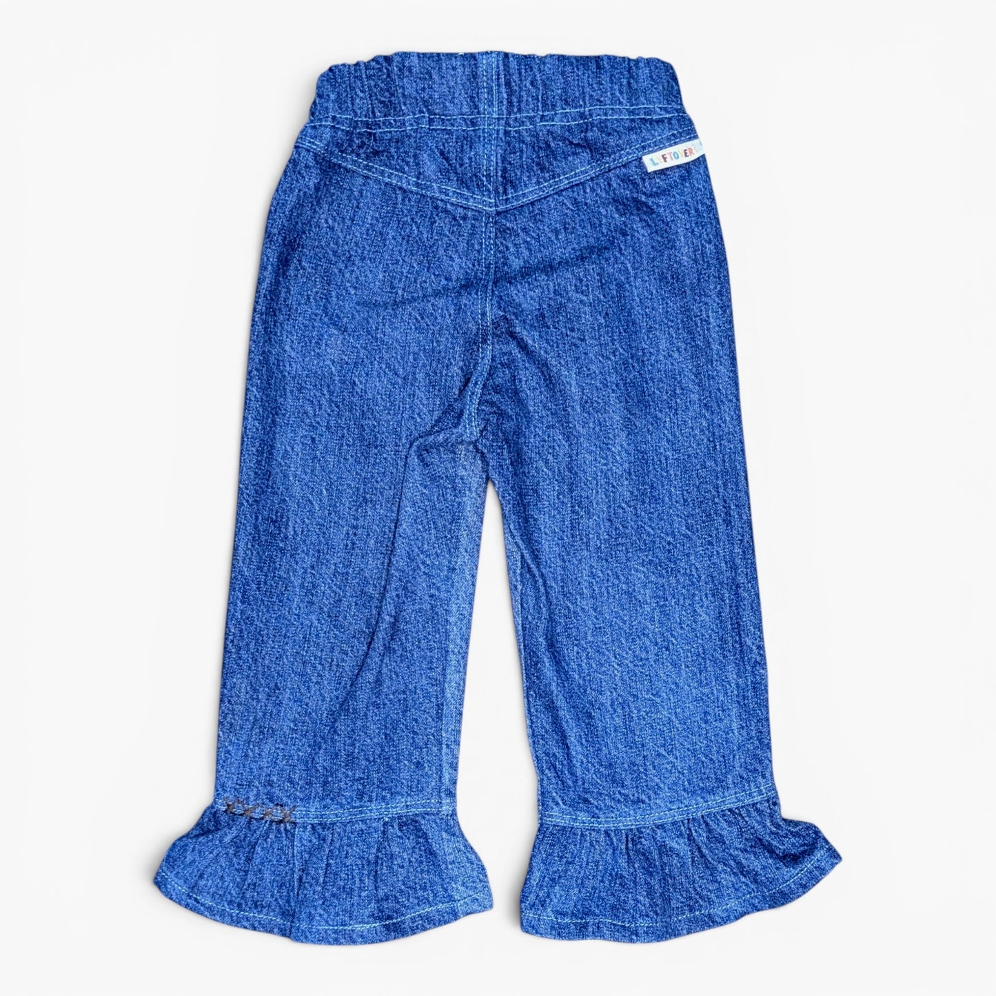 Blue denim pants with a ruffled hem and an elastic waistband, shown flat against a light gray background.