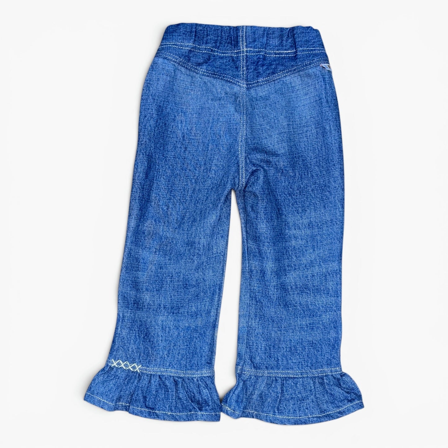 A pair of toddler blue denim flare pants with ruffled hems and decorative white embroidery near the cuffs, shown flat on a light background.