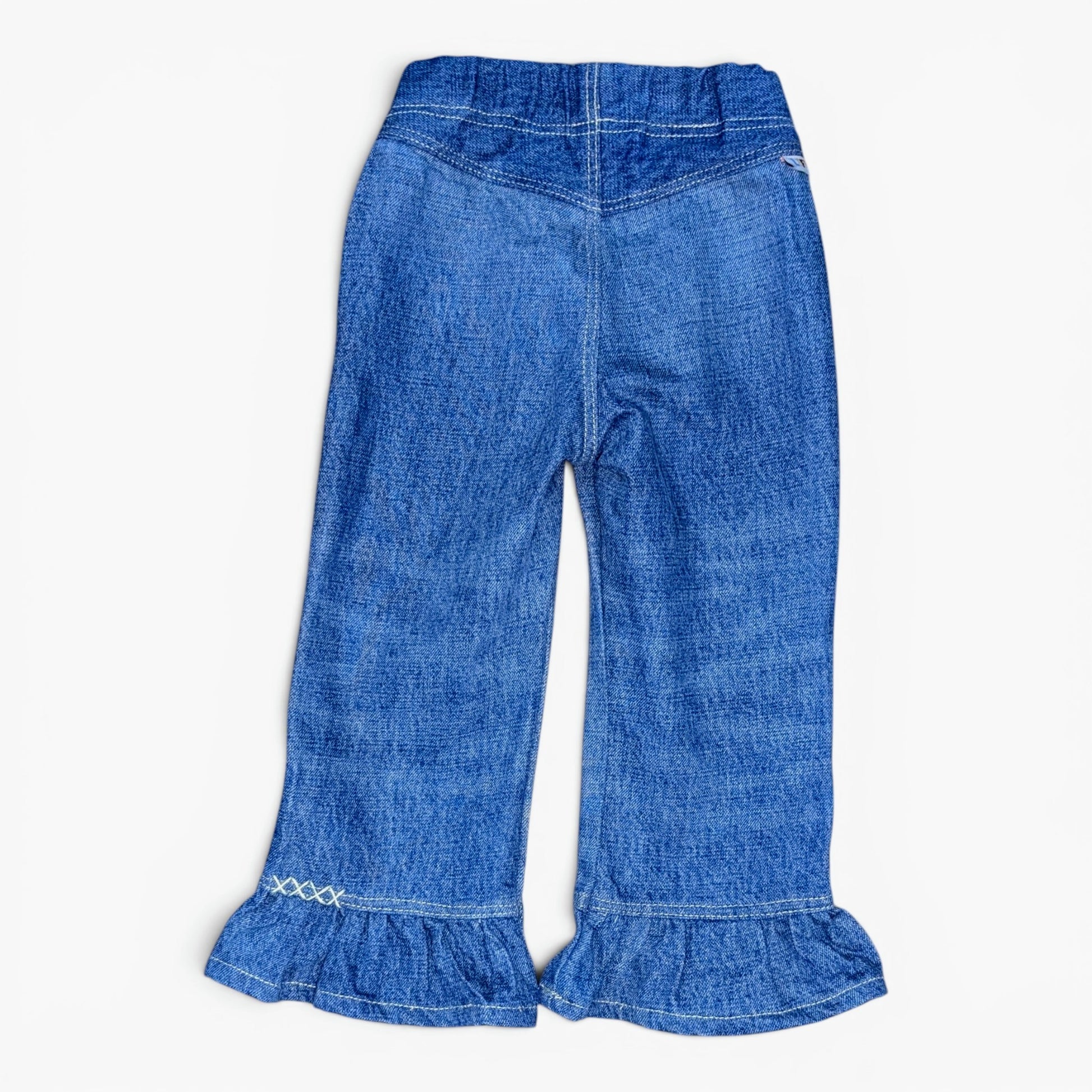 A pair of toddler blue denim flare pants with ruffled hems and decorative white embroidery near the cuffs, shown flat on a light background.