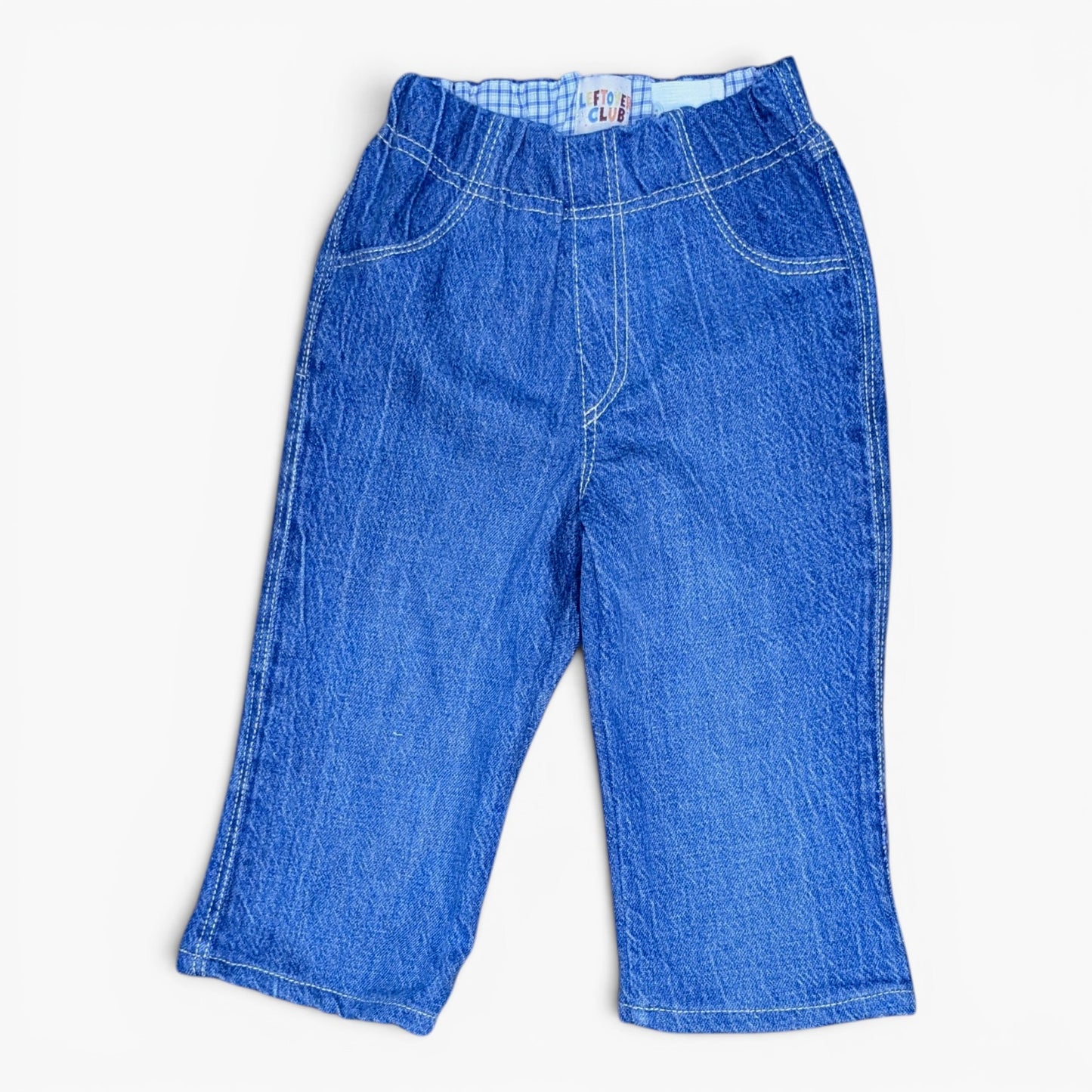 A pair of blue denim pants with a wide elastic waistband, laid flat against a white background.