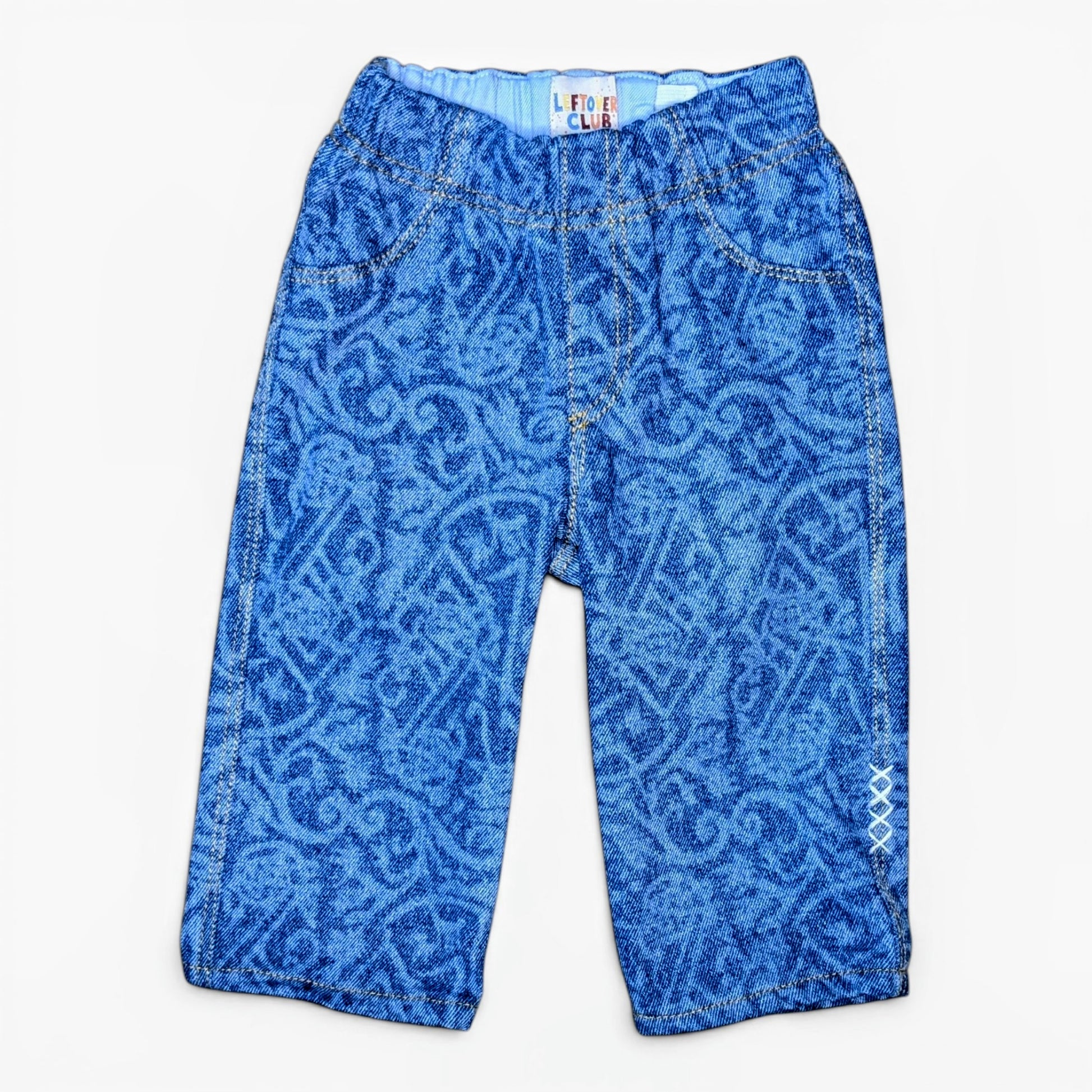 Blue patterned denim pants for toddlers with a graffiti design, laid flat against a white background.