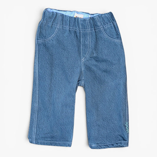 A pair of blue denim jeans for kids, featuring an elastic waistband, front pockets, and contrast stitching, laid flat against a light off-white background.