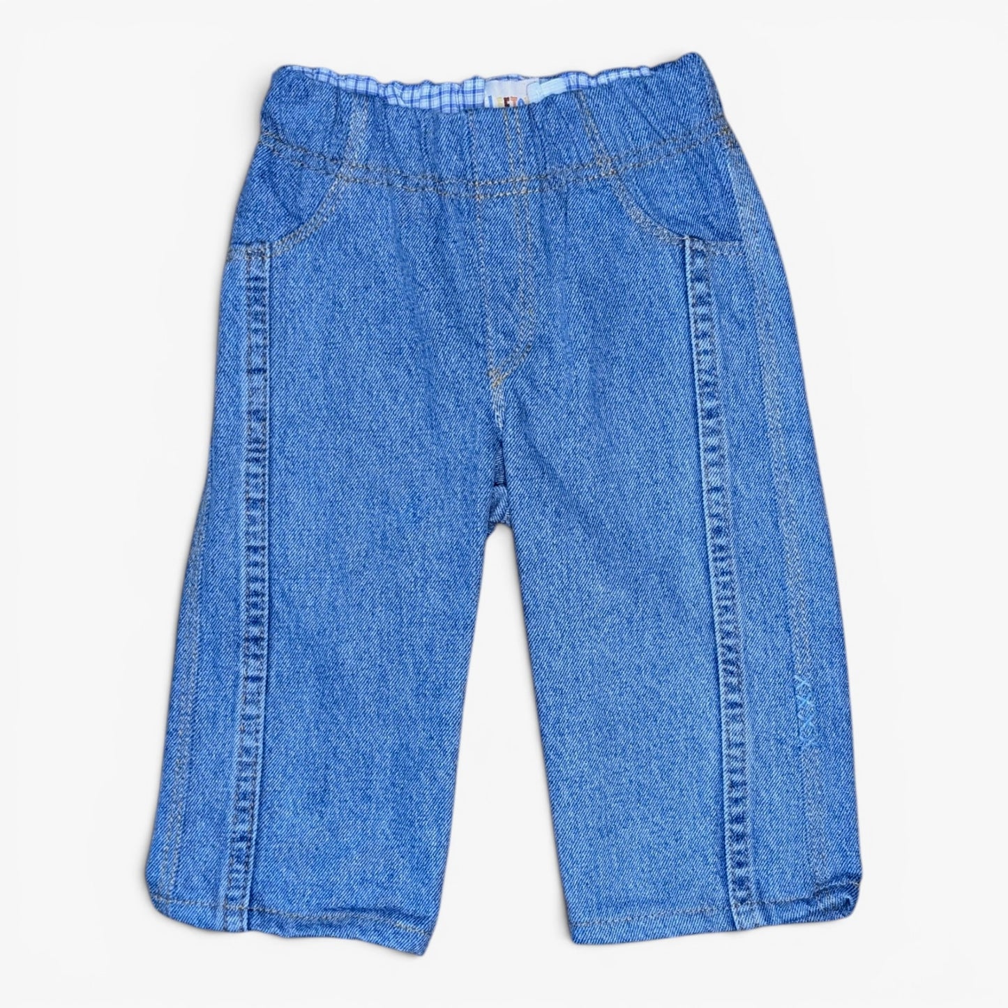 A pair of blue denim pants for toddlers, featuring an elastic waistband and side seam detailing, shown flat on a light background.
