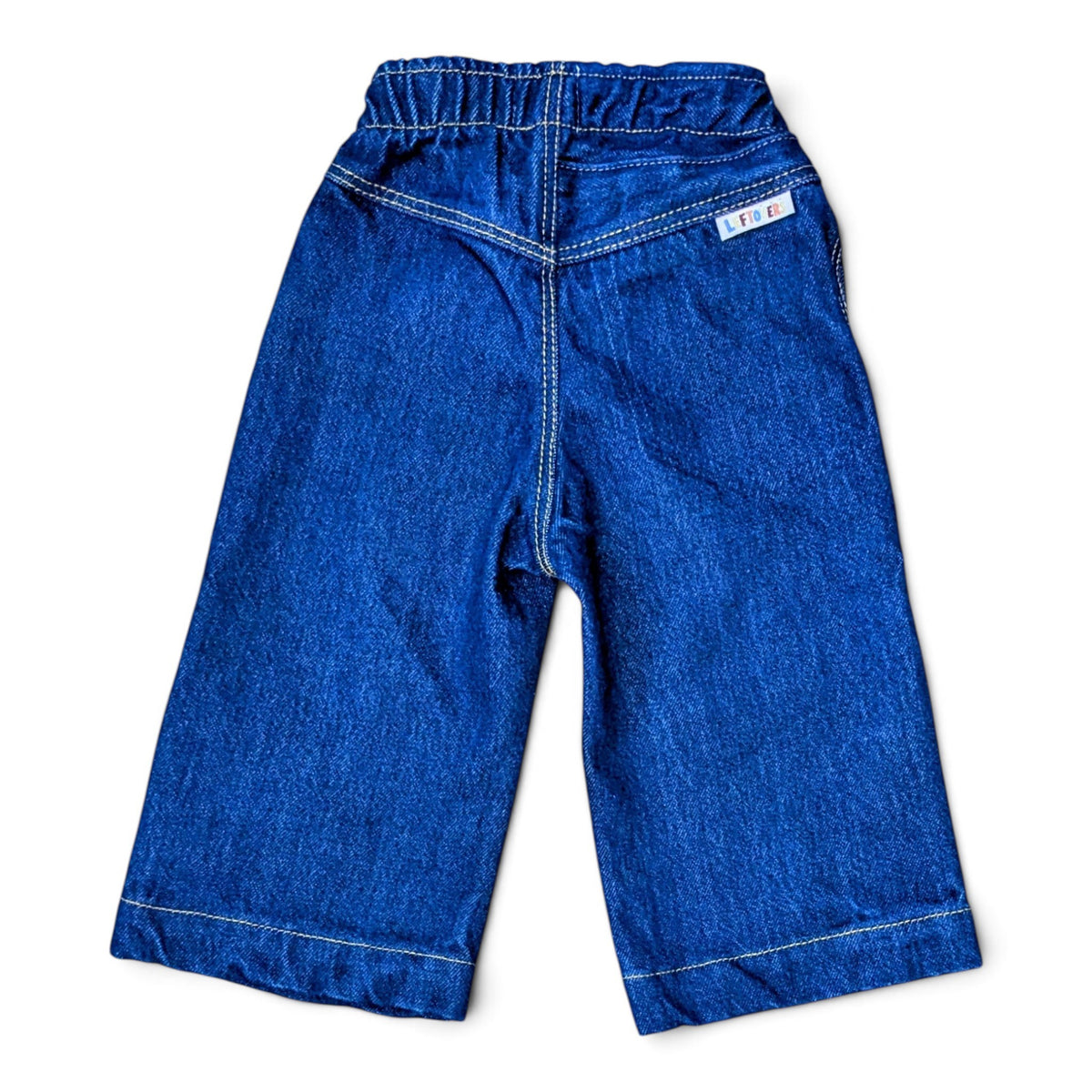 Leftovers Club Winnie Wide and Wavy Jean in a dark mid blue wash with wavy side seams and wide hem. 